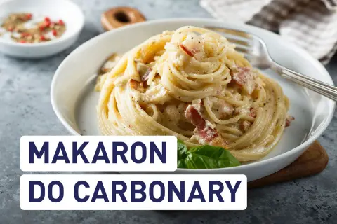 Pyszny makaron do carbonary, idealnie kremowy, z kawałkami boczku i posypany pieprzem.