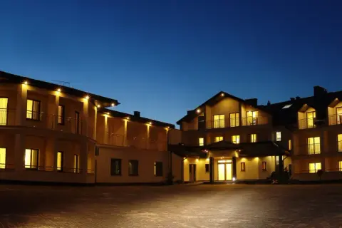 Hotel Rusałka w Okunince nocą, oświetlony, z widokiem na fasadę i balkony.