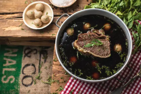 Ein köstliches Tafelspitz-Rezept: Zartes Rindfleisch in dunkler Brühe mit kleinen Klößchen und frischer Petersilie.