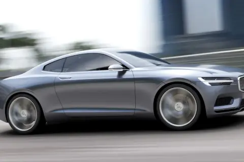 Eleganckie, szare volvo coupe pędzi po drodze, rozmywając tło.