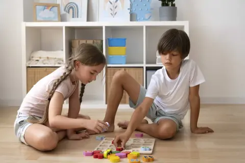 Niños concentrados en un rompecabezas de números, una de las muchas actividades para niños de 6 a 12 años.