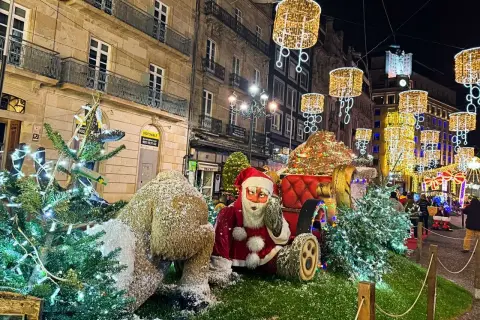 Papá Noel y un reno cubierto de nieve junto a árboles de Navidad adornados con luces. Las calles de Vigo brillan con la magia de la Navidad.