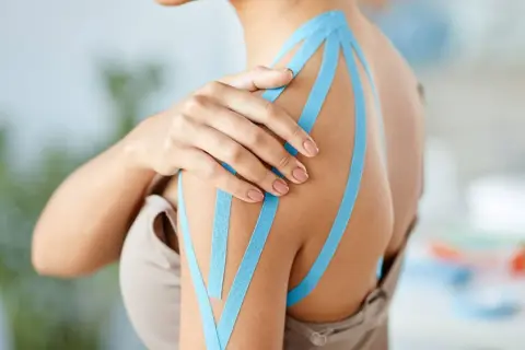 Schulter mit blauem Kinesio-Tape, das den Bereich des plexus brachialis unterstützt.