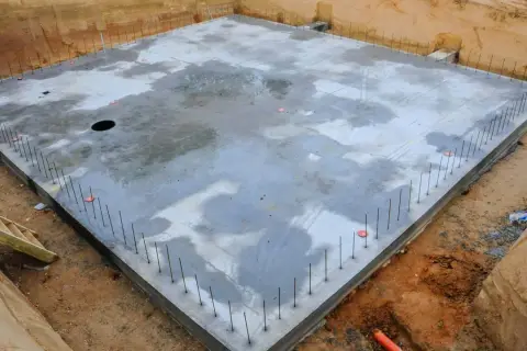 Gotowa płyta fundamentowa, zbrojenie wystające z betonu. Warto sprawdzić płyta fundamentowa koszt, by zaplanować budowę.