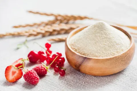 Miseczka pełna semoliny, obok świeże maliny, truskawki i porzeczki. To właśnie semolina co to jest, czyli kaszka z pszenicy durum.