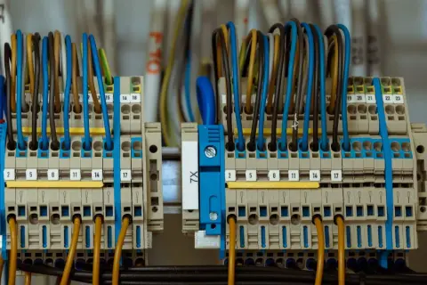 Zasilanie placu budowy z przyłącza docelowego. Widać tu szczegół instalacji elektrycznej z wieloma przewodami w różnych kolorach podłączonymi do listew zaciskowych.