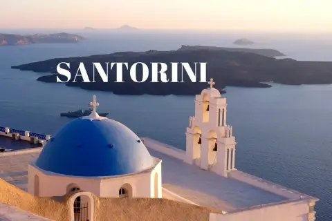 Santorini w maju: błękitna kopuła kościoła i dzwonnica na tle morza i wysp. Idealna pogoda na zwiedzanie.
