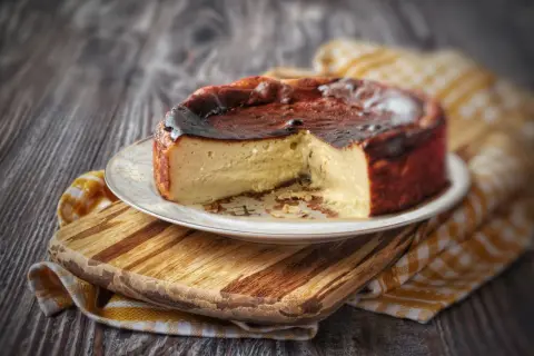 Una golosa cheesecake basca, con la sua crosta caramellata e l'interno cremoso, pronta per essere gustata.
