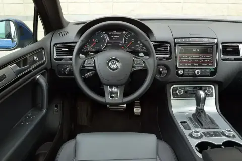 Wnętrze Touarega 3.0 TDI: kierownica, deska rozdzielcza z radiem i panelem klimatyzacji, dźwignia zmiany biegów.
