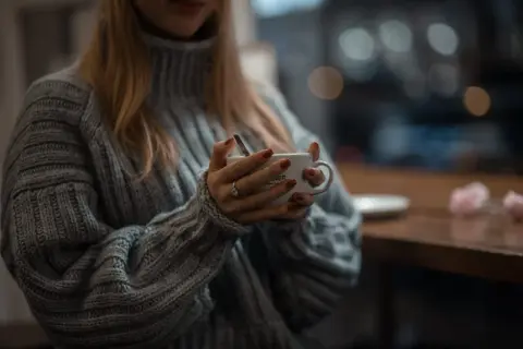 Ciepły, gruby sweter z golfem otula ramiona. Dłonie z rudym lakierem trzymają kubek z kawą. Jak sprawić, by wełna nie gryzła?