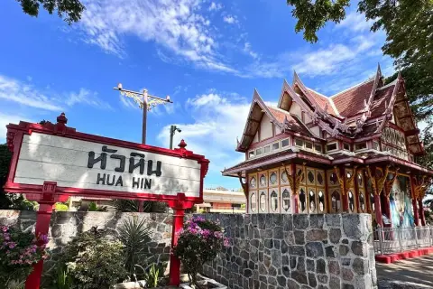 Znak "Hua Hin" przed zabytkowym budynkiem dworca kolejowego w Tajlandii.