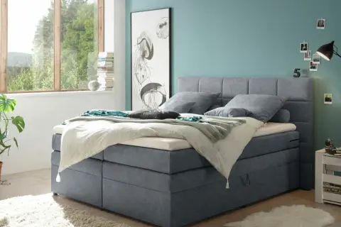 Ein Schlafzimmer mit einem Boxspringbett in Grau und einer Wand in Türkis. Tolle wandfarben ideen für ein maritimes Flair.