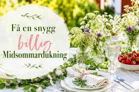En vacker midsommar dukning med blommor, jordgubbar och en inbjudande dukning.