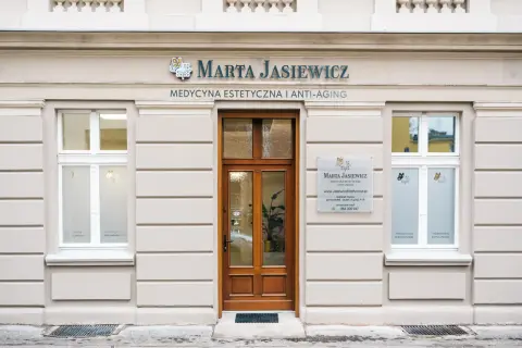 Elegancka fasada kliniki medycyny estetycznej "Marta Jasiewicz" z drewnianymi drzwiami i oknami.