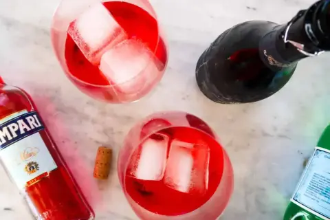 Dwa orzeźwiające drinki z campari, lodem i butelką tego włoskiego likieru. Idealne na letnie popołudnie.