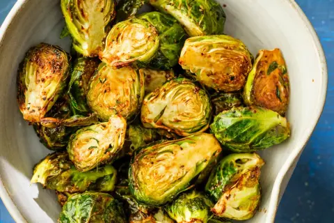Krispiga och gyllene brysselkål i airfryer, serverade i en skål. Perfekt tillbehör!