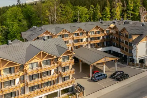 Nowoczesny hotel Platinum Mountain & Spa w otoczeniu lasu. Elegancka architektura z drewnianymi elementami i licznymi balkonami.