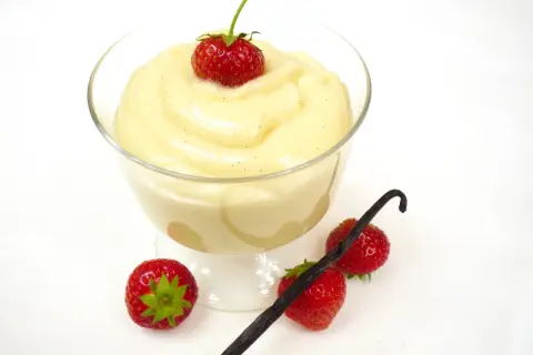 Cremiger Vanillepudding, frisch zubereitet, mit Erdbeeren und Vanilleschote garniert. So einfach ist pudding selber machen!