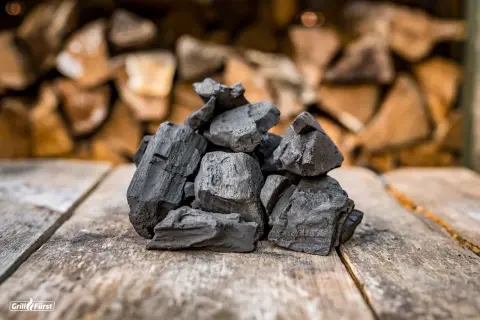 Holzkohle auf Holz, ein Ergebnis der Verkohlung von Holz, zeigt, wie Holzkohle hergestellt wird.