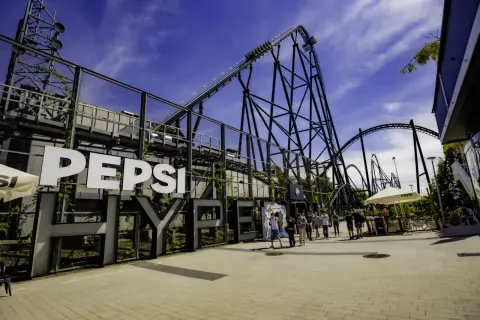 Duża konstrukcja z napisem "PEPSI HYPERION" i kolejką górską w tle.
