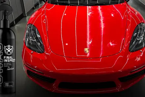 Błyszczący czerwony lakier Porsche i butelka preparatu SWAG Final Inspect. Idealny do tego, czym odtłuścić lakier przed polerowaniem.