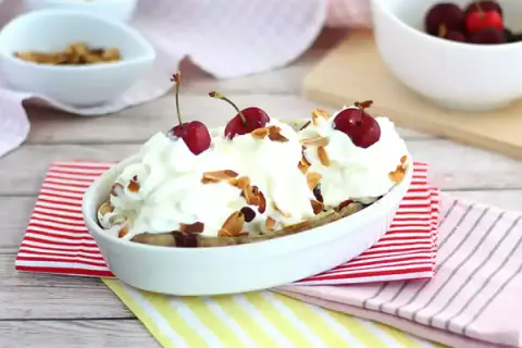 En läcker banana split med vispgrädde, körsbär och mandelflagor. En klassisk dessert som passar alla tillfällen.