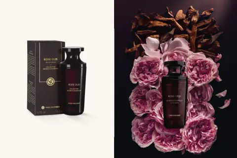 Flakon perfum Rose Oud Yves Rocher otoczony płatkami róż i drewnem oud.
