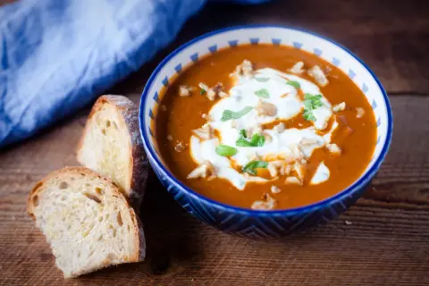 Aksamitna pasta z bakłażana, udekorowana śmietaną i orzechami, podana z chrupiącym pieczywem.