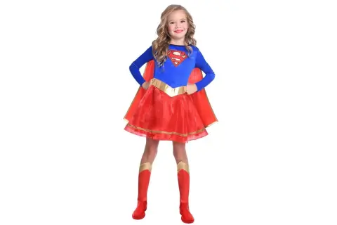 Dziewczynka w stroju Supergirl, idealnym na bal przebierańców. Czerwona spódniczka i peleryna, niebieska bluzka z logo S.