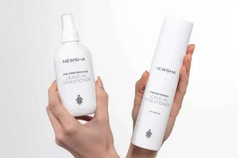 Zwei NEWSHA Leave-In Conditioner Flaschen in Händen. Was ist ein Leave-In Conditioner? Pflege, die im Haar bleibt.