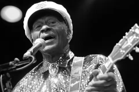 Chuck Berry, ein verstorbener Rockmusiker, singt ins Mikrofon und spielt Gitarre.