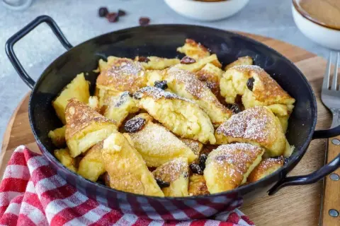 Ein köstlicher Kaiserschmarrn, frisch aus der Pfanne, mit Rosinen und Puderzucker bestäubt. Ein einfaches Rezept für Genuss.
