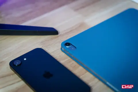 Ciemny iPhone i niebieski iPad na drewnianym blacie, gotowe do aktualizacji do iOS 13.