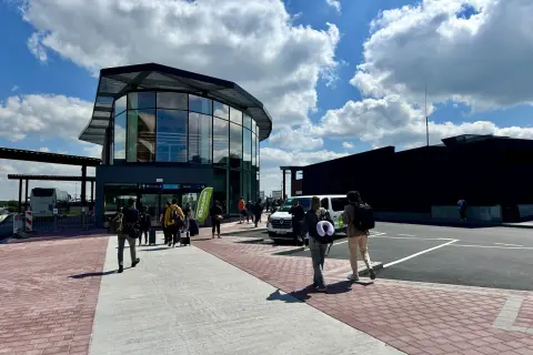 Ludzie z bagażami wchodzą do nowoczesnego terminalu lotniska Bruksela-Charleroi.