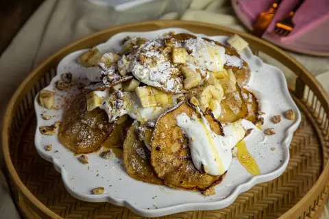 En härlig pannkakstårta med glass, banan och nötter. Pudrad med florsocker och ringlad med honung.