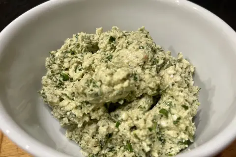 Frisch zubereitetes Moretum-Rezept in einer weißen Schüssel, ein cremiger Käseaufstrich mit Kräutern.