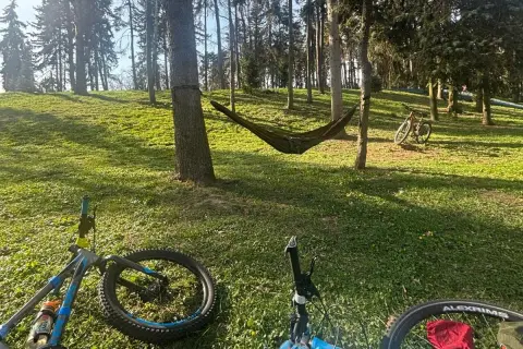 Relaks po rowerowej wycieczce po Warszawie. Hamak między drzewami, rowery czekają na dalszą trasę.