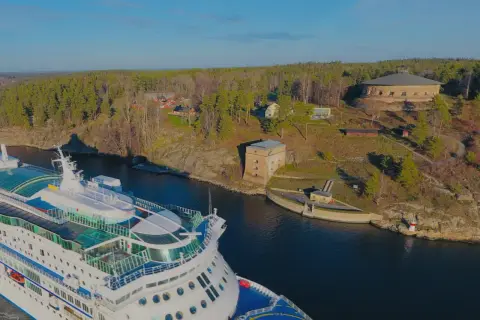 Kryssningsfartyg passerar Fredriksborgs hotell och fästning i en vacker svensk skärgårdsmiljö.