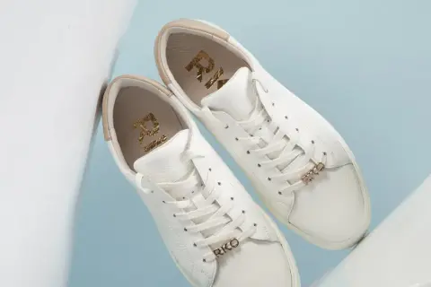 Białe buty sneakersy, co to znaczy? Stylowe, skórzane, z złotymi detalami RKO.