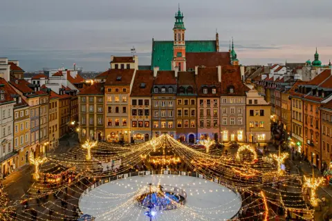 Magiczny zimowy wieczór w Warszawie. Rynek Starego Miasta rozświetlony tysiącami lampek, lodowisko i choinka tworzą idealny klimat na city break w Polsce.