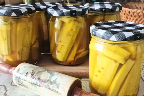 Słoiki z cukinią w zalewie słodko-kwaśnej z curry, gotowe do spiżarni.