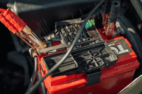Kable rozruchowe podłączone do czerwonego akumulatora. Zastanawiasz się, jak długo alternator ładuje akumulator?