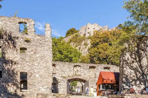 Ruinen der Hohentwiel Burg thronen auf einem Hügel. Im Vordergrund ein Torbogen und ein kleiner Kiosk.