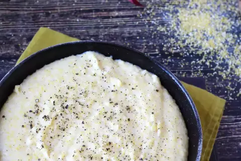 Krämig polenta i gjutjärnspanna, strödd med peppar. Perfekt för ett enkelt polenta recept.