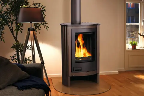 Stufa a legna nordica accesa, con fiamme vive. Un'idea su come pulire la stufa a legna nordica per mantenerla efficiente e bella.