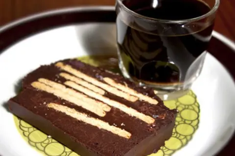 En bit chokladkaka med kex, perfekt för ett radiokaka recept original. Serveras med en kopp kaffe.