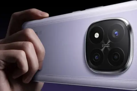 Dłoń trzyma fioletowy telefon z aparatem jak lustrzanka, z czterema obiektywami.