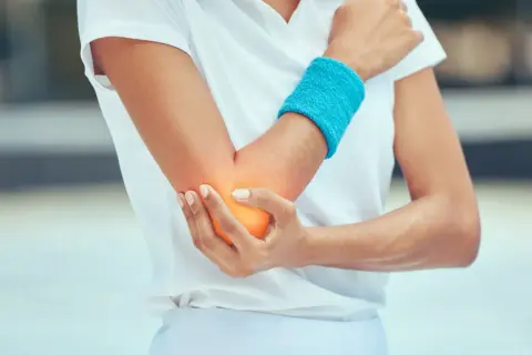 Schmerzende Ellenbeuge bei einem Sportler. Tennisarm tapen sinnvoll zur Entlastung.
