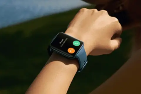 Reloj inteligente con pantalla táctil, similar a un Apple Watch, pero compatible con Android. Muestra una llamada entrante con opciones para aceptar o rechazar.