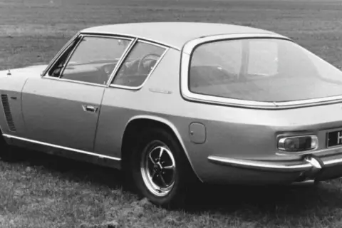 Ein Jensen Interceptor Auto steht auf einer Wiese. Das Heck des Wagens mit dem Kennzeichen "HEA ID" ist zu sehen.